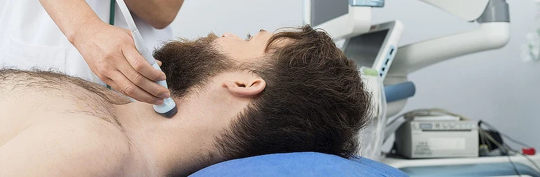 Ultrazvukové vyšetření krku pacienta lékařem v ordinaci.