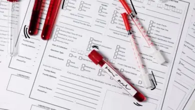Krevní vzorky v testovacích zkumavkách s formuláři pro lékařskou analýzu.