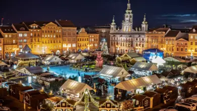 Vánoční trh na náměstí s trhy, ledu a osvětlenými budovami.