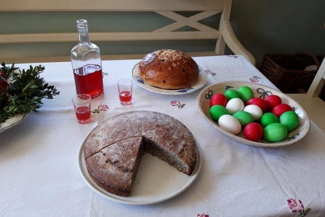 Stůl s velikonočními pokrmami a nápoji na bílé ubrus.