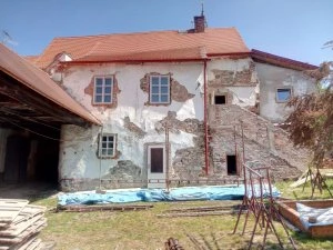 Renovace domu s aplikací vápenné omítky na fasádě.