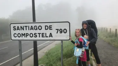 Rodina s dítětem u značky Santiago de Compostela na Caminu.