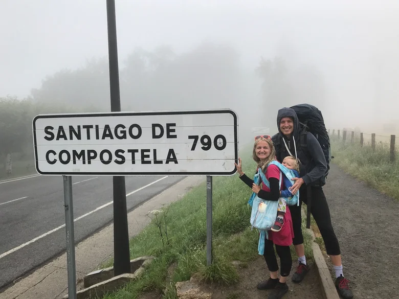 Rodina s dítětem u značky Santiago de Compostela na Caminu.
