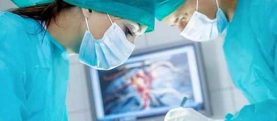 Dva chirurgové v modrém oblečení provádějí operaci.